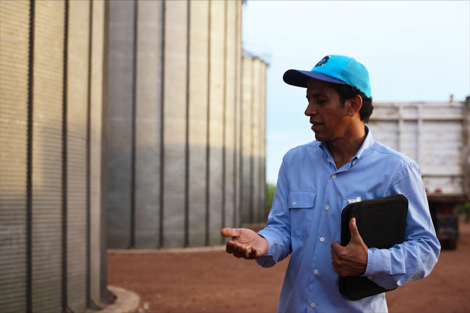 Comprador revisando la calidad de la soja frente a los silos